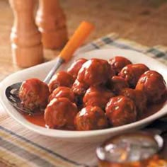 a white plate topped with meatballs covered in sauce