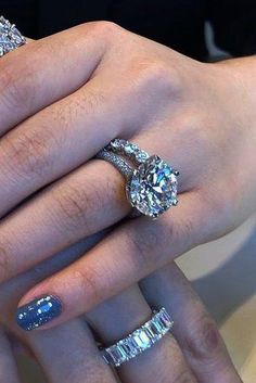 a woman's hand with two rings on it and three diamond bands around her fingers