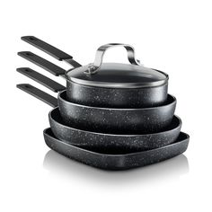 three black pots and pans stacked on top of each other with spatulas