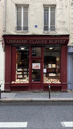 a store front with many books on display in it's windows and the words library caude buffet