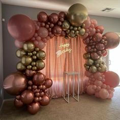 an arch made out of balloons with the words happy birthday written on it in gold and pink