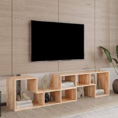 a flat screen tv mounted to the side of a wooden wall in a living room