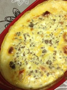 a casserole dish with meat and cheese on it sitting on a tablecloth