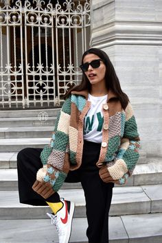 a woman sitting on the steps wearing sunglasses