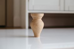 a wooden vase sitting on top of a white counter