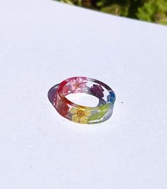 This pride ring has been decorated with different flowers with different colours. If you wish to change the pride colours to another flag, please message me. Colorful Handmade Rings For Gifts, Colorful Handmade Rings As Gift, Multicolor Flower Shaped Jewelry With Pressed Flowers, Colorful Handmade Ring Gift, Multicolor Flower Jewelry With Pressed Flowers, Multicolor Flower Ring As Gift, Multicolor Flower Ring Gift, Rainbow Flower-shaped Jewelry For Gifts, Multicolor Flower Ring As A Gift