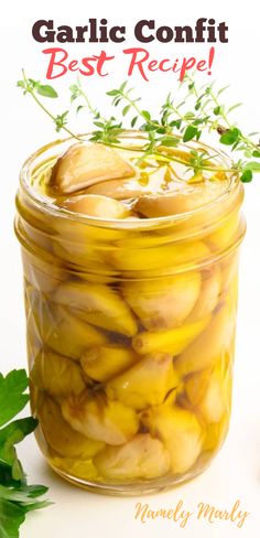 garlic confit in a glass jar with herbs on top and text overlay that reads garlic confit best recipe