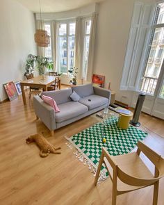 a living room filled with furniture and lots of windows next to a wooden floored floor