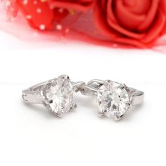 pair of white gold diamond earrings with red rose in the backgroung background