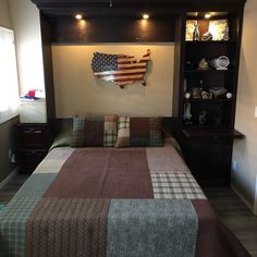 a bed room with a neatly made bed next to a book shelf and shelves on the wall