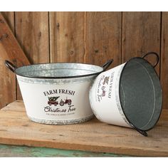 two buckets sitting on top of a wooden table next to each other with farm fresh written on them