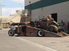 an old truck is being loaded onto a flatbed trailer