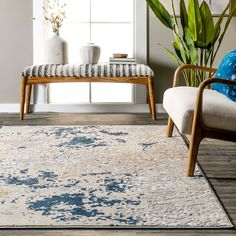 a living room area with two chairs and a rug on the floor in front of a window