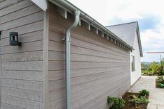 the side of a house with a metal gutter attached to it