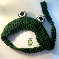 a crocheted frog hat with eyes on it