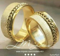 two gold wedding rings sitting on top of each other