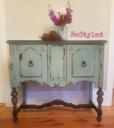 an old dresser is painted blue and has flowers on top