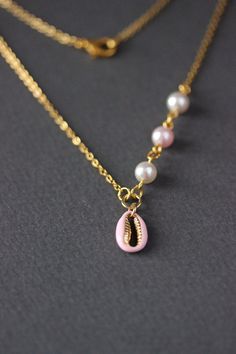 This dainty summer beach style necklace was made of delicate light pink enamel cowrie shell gold tone stainless steel charm, finest quality European crystal pearl coated white and light pink 6 mm beads, gold tone steel jumping rings and gold tone stainless steel chain with gold tone lobster claw. The chain is from lead free & nickel free metal. The length of necklace is 47.5 cm or 18.5 inches. Shell bead size: 9x13 mm. Other necklaces of my shop you can see here: https://www.etsy.com/shop/Na Summer Dainty Pearl Chain Jewelry, Dainty Pearl Charm Necklace For The Beach, Dainty Necklaces For Vacation, Pink Shell-shaped Jewelry For Summer, Pink Shell Jewelry For Summer, Pink Shell-shaped Summer Jewelry, Pink Shell-shaped Necklace For Beach, Summer Gift Pink Shell Necklace, Pink Dainty Pearl Chain Jewelry