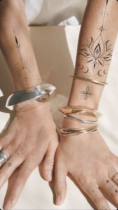 two people with tattoos on their arms holding hands