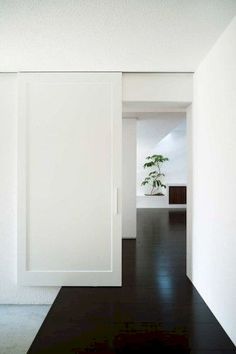 an empty room with white walls and black floors