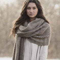 a woman standing in the snow wearing a scarf