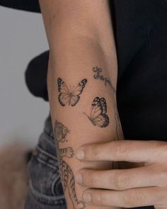 a woman's arm with butterflies on it and the word love written in cursive writing