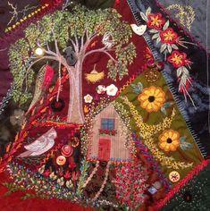 a patchwork quilt with trees, flowers and birds in the center on top of it