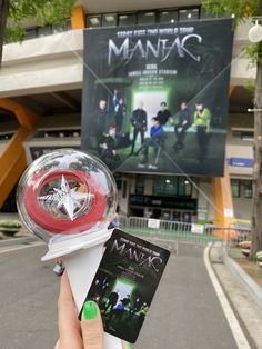 a person holding up a toy with a movie poster in front of them on the street