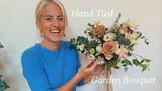 a woman holding a bouquet of flowers with the words hand tied garden bouquet