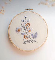 a white wall hanging with a floral embroidery pattern on it's front and back