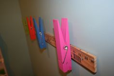 there are three different colored wooden rulers on the wall