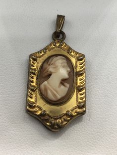 "A beautiful unique antique victorian cameo photo locket pendant made in with 12k gold filled in old good condition measures approx. 1 1/2\" x 3/4\" width." Cameo Medallion Locket Necklace, Victorian Cameo Locket Necklace For Formal Occasions, Vintage Cameo Pendant Locket Necklace, Antique Brass Cameo Locket Necklace, Brass Medallion Locket Necklace With Cameo, Antique Gold Cameo Medallion Locket Necklace, Victorian Gold Cameo Locket Necklace, Antique Cameo Medallion Locket Necklace, Antique Gold Cameo Locket Necklace