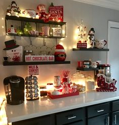 a kitchen counter topped with lots of christmas decorations and lights on it's shelves