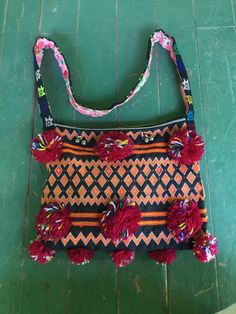 a colorful purse sitting on top of a green floor