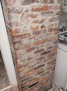 an old brick wall in the corner of a kitchen