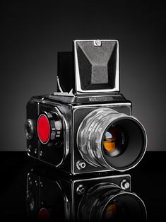 an old fashioned camera with a red lens