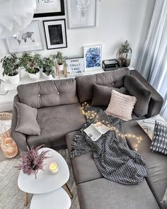 a living room with grey couches and pictures on the wall above it, along with other furniture