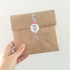 a person holding an envelope with a sticker that says nish love on it