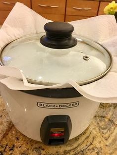 a black and decker slow cooker sitting on top of a counter next to flowers