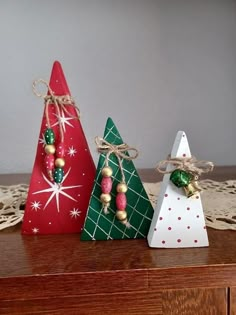 three small wooden christmas trees on a table