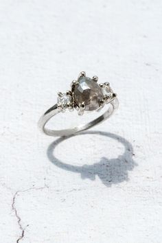 a white gold ring with three diamonds on the top and one stone in the middle