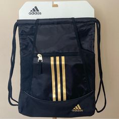 This Adidas Alliance Ii Sackpack Transports Your Gym Clothes And Equipment Comfortably And Has A Pocket To Protect Valuables Like Your Phone. Sturdy Polyester Fabric Front Zip Pocket Mesh Water Bottle Pockets At Sides Drawstring Top Closure Sturdy Rope Shoulder Straps Three-Stripe Front Detail With Metallic Finish Black / Gold Metallic External Dimensions (Hxwxd): 17.5x13.5x1.5" Made In Cambodia Adidas Casual Sports Gym Bag, Functional Black Adidas Gym Bag, Adidas Casual Travel Gym Bag, Casual Adidas Gym Bag For Travel, Casual Black Adidas Gym Bag, Adidas Casual Backpack For Gym, Adidas Black Gym Bag, Adidas Casual Gym Backpack, Adidas Gym Bag For Back To School