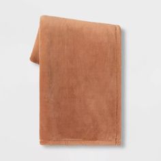 a brown towel folded on top of a white wall