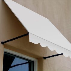 a white awning hanging from the side of a building next to a door and window