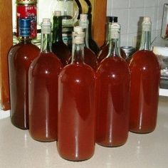 six bottles of liquid sitting on top of a counter