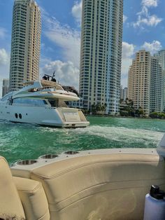 a motor boat traveling through the water in front of high rise buildings