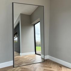 a large mirror sitting on top of a wooden floor