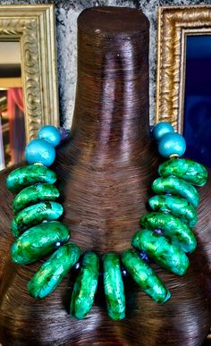 Just look at the colors on this OOAK Art to Wear Statement Necklace from Kat Kouture. Thirteen "slices" of green lusciousness form the frontal portion with each hand sculpted bead separated from the other by a small blue aurora borealis crystal. Larger metallic robin's egg blue round beads are positioned toward the back with gold aurora borealis rhinestone rondelle separators. Purple and blue faceted crystals form the back with gold tone metal bi-cones. Closes with a fancy XL lobster claw clasp. Luxury Green Large Beads Jewelry, Green Large Bead Costume Jewelry Necklace, Unique Hand-strung Green Beaded Necklaces, Green Faceted Beads Costume Necklace, Rocker Chic Accessories, Emerald Green Jewelry, Luxury Statement Beads, Gems, And Cabochons, Blue Aurora, Blue Aurora Borealis