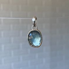 A silvery-blue freeform rose cut moss aquamarine is encased in sterling silver and hangs from a tapered, faceted bail.Chain sold separately. Shown on the model paired with a silver curb chain. You can view our chain options to add here: https://coreyegan.com/products/chain-silver Product Details 4.48ct Moss Aquamarine Pendant measures 7/8" L x 7/32" W sterling silver Bail opening is 3.3mm Pendant only. Chain sold separately. Silver Blue Topaz Briolette Jewelry, Silver Briolette Blue Topaz Jewelry, Silver Oval Apatite Jewelry, Silver Aquamarine Jewelry With Bezel Setting, Silver Teardrop Aquamarine Jewelry, Handmade Silver Jewelry With Green Amethyst, Faceted Sapphire Silver Jewelry, Stacked Engagement Ring, Montana Sapphire Engagement Ring