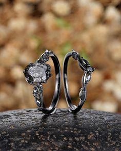 two wedding rings sitting on top of a rock